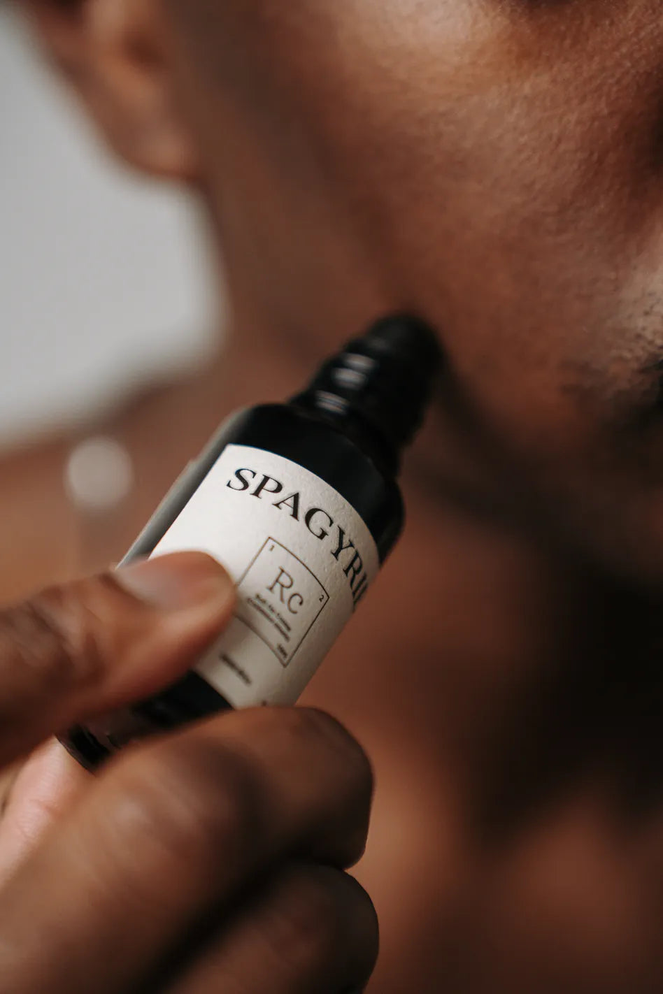 Application d’un soin barbe Spagyrie sur la joue, geste précis pour stimuler naturellement la pousse de la barbe chez l’homme
